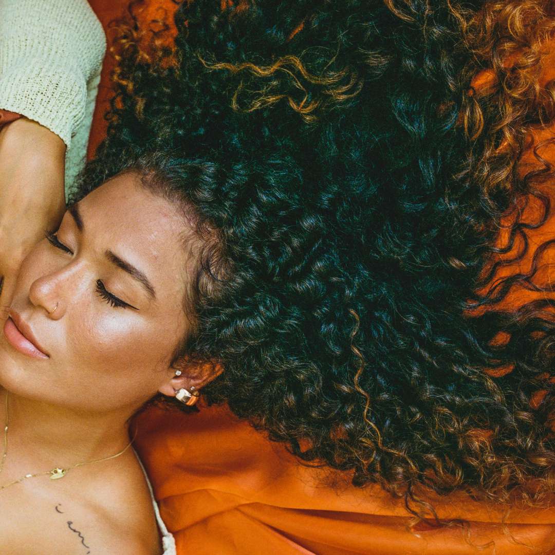 Hair stylist performing a curl styling session on a client