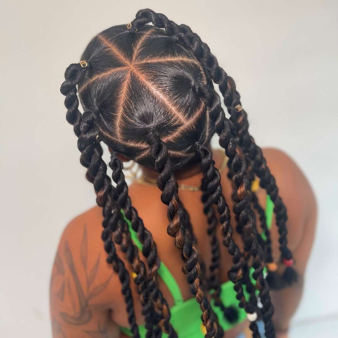 Salon client with long boho knotless braids extensions in 1B deep brown, styled for protective curly hair care at Des Curl Spa